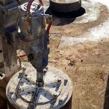 Large-diameter core rig set up on a slab, the cut core standing beside it