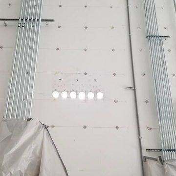 Rows of small cores drilled through a wall for anchors