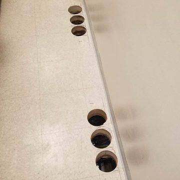 A line of cores drilled along the edge of a concrete beam