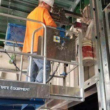 Operator core drilling overhead from a scissor lift
