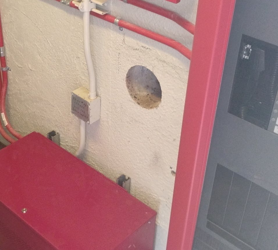 The finished core hole in the wall of a Central Arizona Project checkpoint room in Tempe, conduit runs back in place