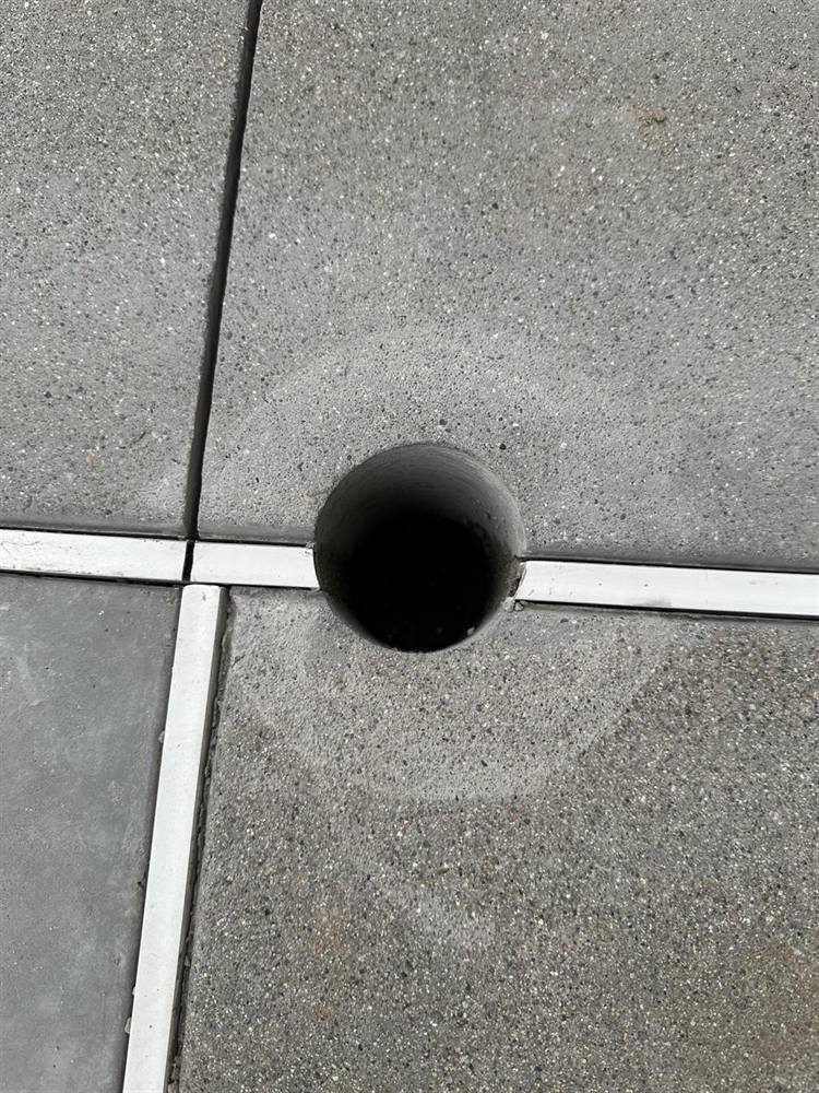 Close-up of a clean 3-inch core hole for a handrail post at a joint in the new plaza concrete at the Glendale civic campus