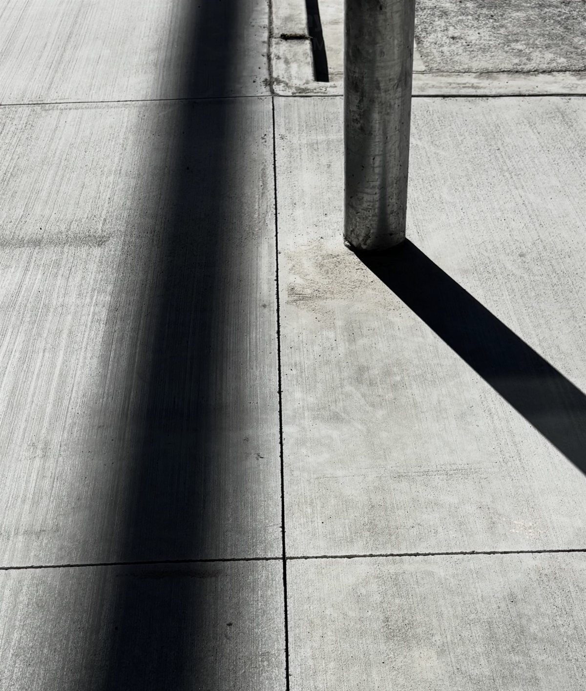 Early entry control joints cut square around a bollard on a new walk at Papago Marketplace in Scottsdale
