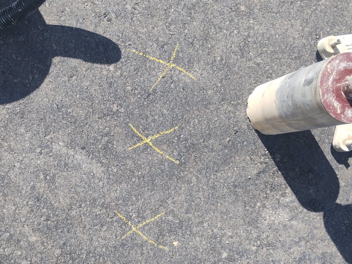 Yellow layout marks for core locations on asphalt with the core barrel and vacuum beside them, Prescott Arizona