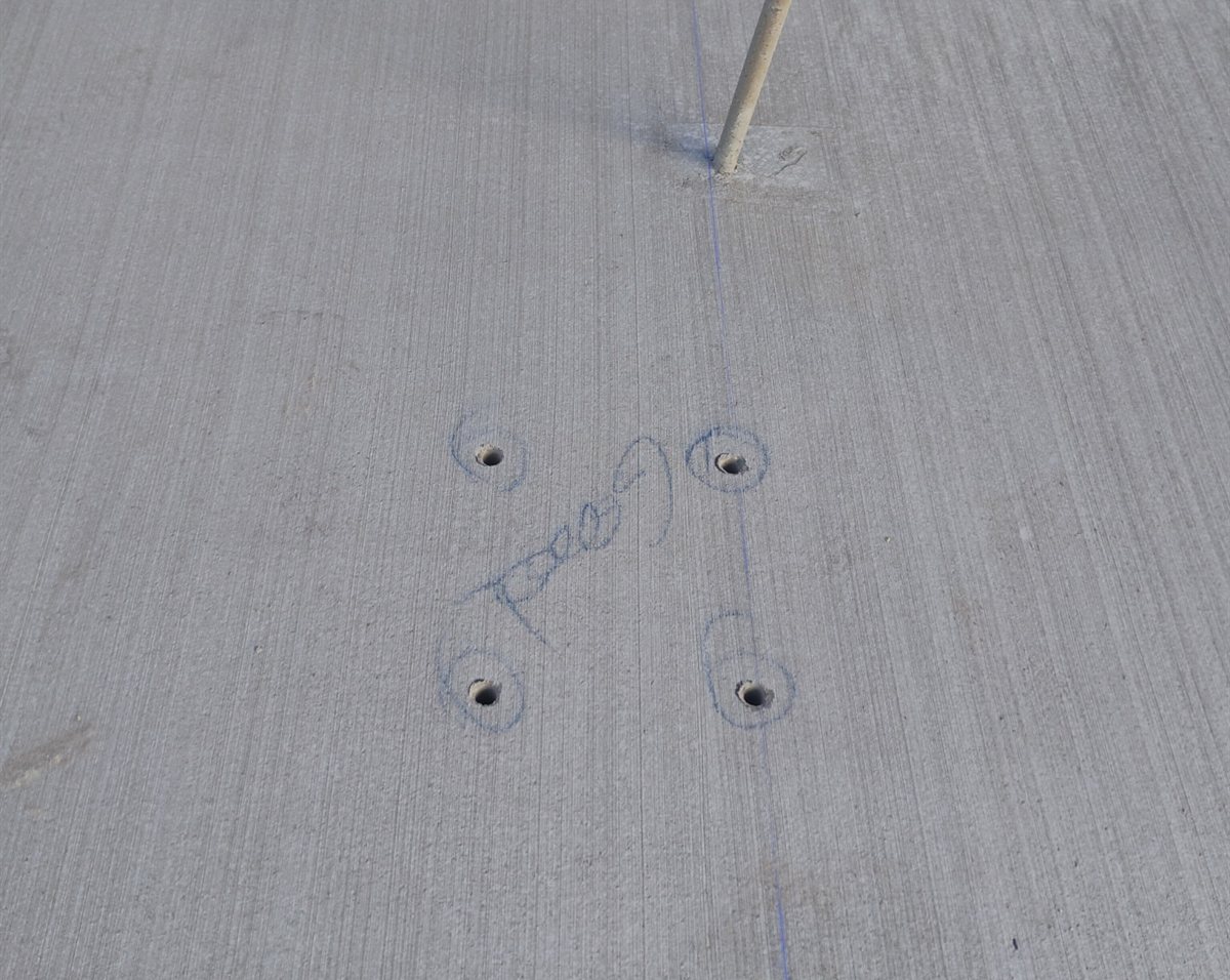 One-inch drilled holes on the snapped layout lines beside a conduit stub, Queen Creek