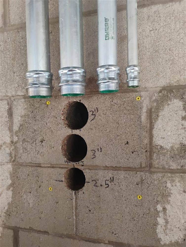 Three clean cores drilled through a block wall in Scottsdale, ready for electrical conduit