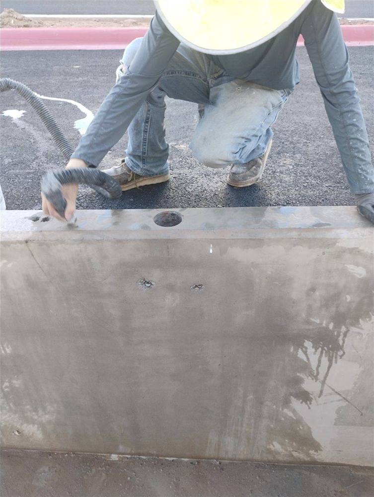 Concrete Coring Company technician vacuuming slurry off a wall top after drilling cores down through it in Scottsdale